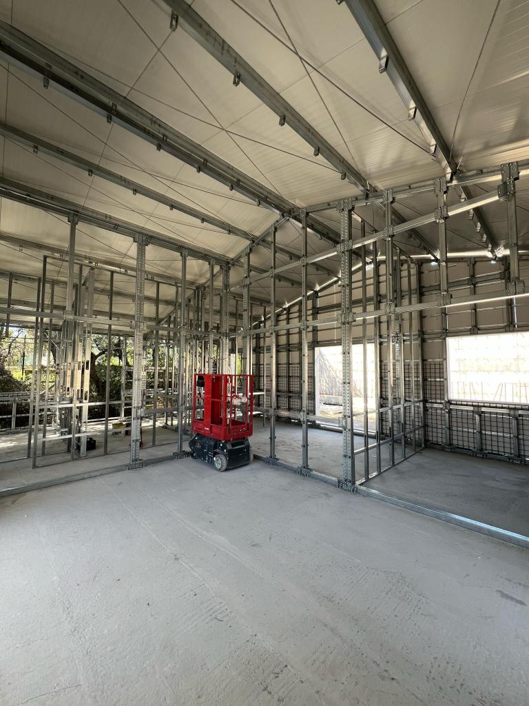 Interno di edificio in costruzione con struttura in acciaio e piattaforma elevatrice